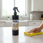 Person cleaning a kitchen counter with a yellow cloth and a bottle of 'Wipe Right' cleaner.