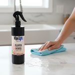 Person cleaning a surface with a bottle of 'Wipe Right Flower Power' cleaner.