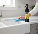 Person cleaning a kitchen counter with a bottle of Wipe right Lemon-aid cleaner.